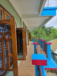 a corridor of a house with blue and red stairs at Sharma Residency in Dithur