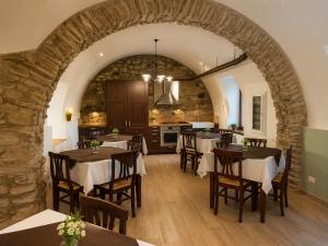 a dining room with tables and a stone wall at Podere Meroli in Scorcetoli