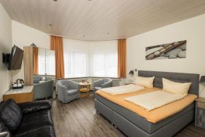 a bedroom with a bed and a living room at Hotel Restaurant Ketterer am Kurgarten in Triberg