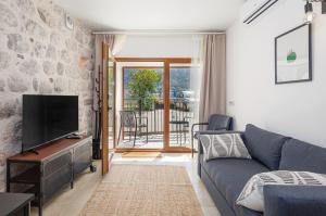 a living room with a couch and a tv at Historic Waterfront Apartment in Muo +35 photos