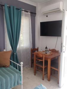 a dining room with a table and a television at Αλέξανδρος 3 in Myrina
