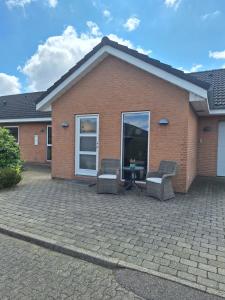 a brick house with two chairs and a table at Nice room with a wonderful view in Sommersted