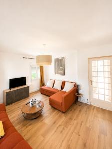 a living room with a couch and a table at Maison moderne Parking &Jardin in Narbonne