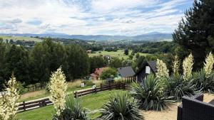 a view of a farm with mountains in the distance at Babia Góra View House in Kocierz Moszczanicki