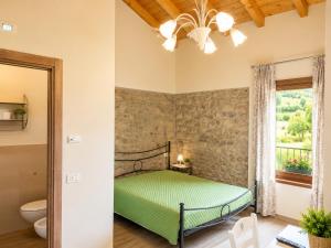 a bedroom with a green bed and a window at Podere Meroli in Scorcetoli