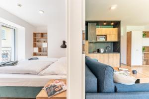 a bedroom with a bed and a blue couch at APARTAMENTY ZDROJOWA 9 in Duszniki Zdrój