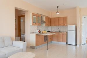 a kitchen with wooden cabinets and a white refrigerator at Kos Happy living in Lampi