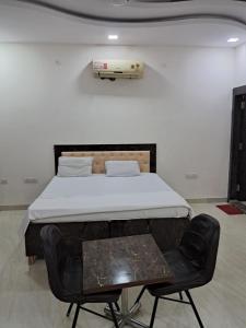 a bed in a room with a black chair at PLAY HOTEL PREET RESIDENCY couple friendly in Greater Noida