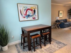 a wooden table and stools in a living room at Modern condo right across from beach and pool in Galveston