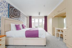 a bedroom with a large bed with purple accents at Talbot House by Grandeur Property in Bournemouth