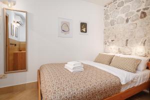 a bedroom with a bed with a stone wall at Historic Waterfront Apartment in Muo