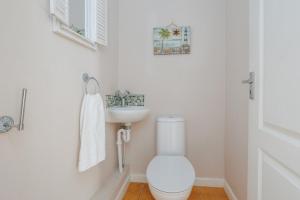 a white bathroom with a toilet and a sink at Talbot House by Grandeur Property in Bournemouth +26 photos