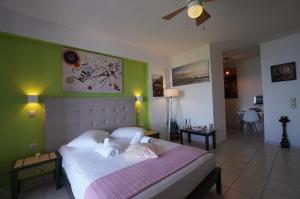 a bedroom with a large bed with green walls at Saltwater Serenade Apartments in Zakynthos +28 photos