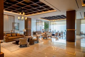a lobby with couches and chairs in a building at Rich Palace Hotel in Surabaya