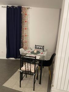 a dining room table with a chair and a blue curtain at Jana holiday in Paris in Arcueil +22 photos