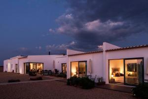 a large white building with windows at night at Agroturismo Xistos in Cerca