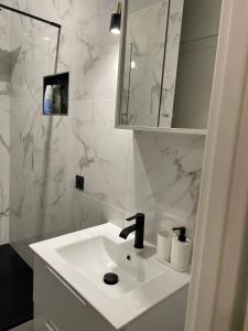 a white bathroom with a sink and a mirror at Jana holiday in Paris in Arcueil