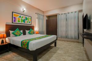 a bedroom with a large bed and a television at Treebo Ksheera Residency Near Railway Station in Hassan +19 photos