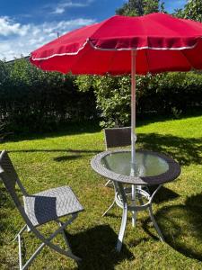 a table and two chairs with a red umbrella at Martan Porti Three-bedroom house in Imatra