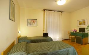 1 dormitorio con 2 camas y escritorio con ordenador portátil en Hotel Agli Olmi, en San Biagio di Callalta