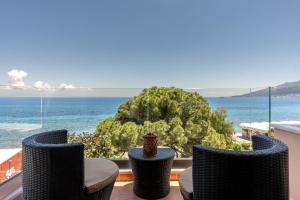 a balcony with chairs and a view of the ocean at Saltwater Serenade Apartments in Zakynthos