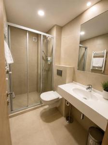 ein Badezimmer mit Dusche, Toilette und Waschbecken in der Unterkunft Hotel Rhodos in Eforie Nord + 43 Fotos