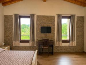 a bedroom with a bed and a desk with a television at Podere Meroli in Scorcetoli