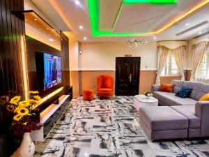 a living room with a couch and a flat screen tv at Imtech Luxury Apartments in Uyo