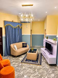 a living room with a couch and a tv at Imtech Luxury Apartments in Uyo