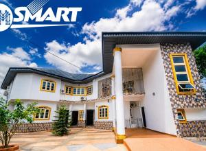 a white house with yellow windows at Imtech Luxury Apartments in Uyo