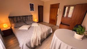 a bedroom with a large bed and a table at Ēmužas in Dārte