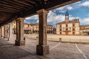 an old building with a clock tower in a town at El Rincón De Tere in Riaza