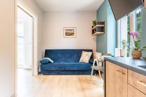a blue couch in a living room with a table at APARTAMENTY ZDROJOWA 9 in Duszniki Zdrój
