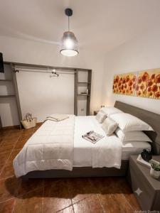 a bedroom with a large white bed and a lamp at Dimora Filangeri in Santa Flavia