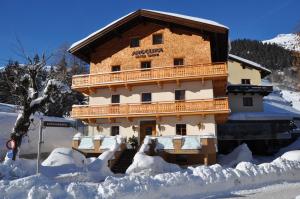ein Gebäude im Schnee mit Schnee um ihn herum in der Unterkunft Hotel Angelika in Sankt Anton am Arlberg