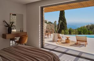 a bedroom with a bed and a large glass window at Doci Kelios - Serenity Suites with Private Heated Pools, by ZanteWize in Agios Nikolaos +64 photos