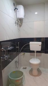 a bathroom with a toilet and a water tank at The Hilltop inn in Kelghar