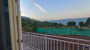 a view from a window of a fence and mountains at The Hilltop inn in Kelghar