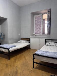 a room with two beds and a window at Olympic Hostel in Yerevan