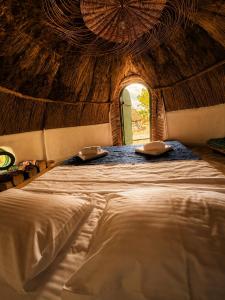 a large bed in a room with a ceiling at La Colibe, cătun arhaic ecologic in Corbu +131 photos