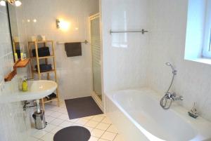 a white bathroom with a tub and a sink at Zaumseil, Axel Fe-App "unten" in Schönberg