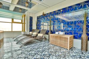 Habitación con paredes y sillas azules y blancas. en AG Hotel, en Abu Dabi