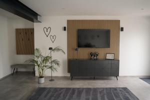 a living room with a flat screen tv on a wall at Ferienwohnung Eifelmomente in Rittersdorf