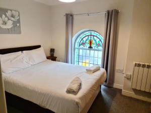 a bedroom with a bed and a stained glass window at Tees Valley Apartments in Middlesbrough