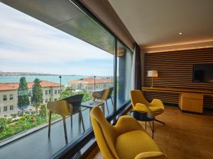 a room with a large window with chairs and a television at Metropolitan Hotels Bosphorus - Special Category in Istanbul
