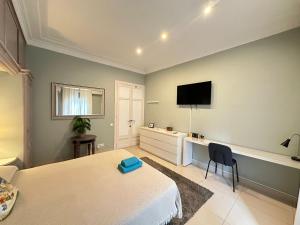 a bedroom with a bed and a tv on the wall at Rooms Granvia in Barcelona