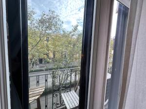 a balcony with a bench looking out of a window at Rooms Granvia in Barcelona