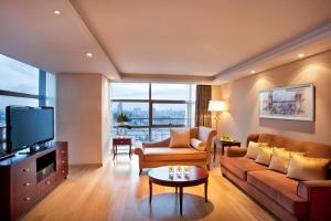 un soggiorno con divano e TV di Regal Plaza Hotel & Residence a Shanghai