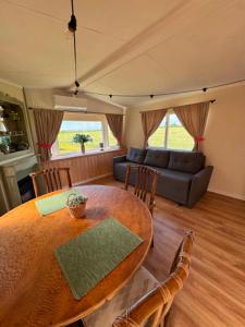 a living room with a wooden table and a couch at Między polami in Drewnica