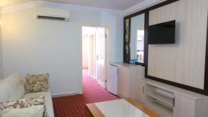 a living room with a television and a couch at AZAK BLUE OTEL in Okurcalar
